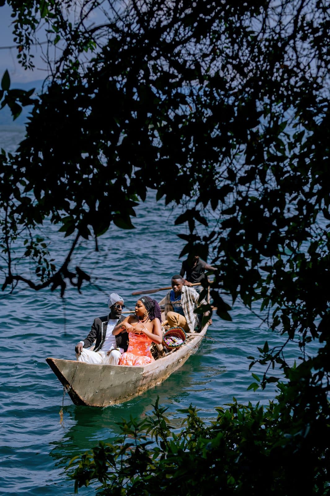 Visitors paddling a canoe between the wooded islands of Lake Kivu